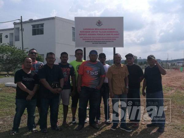 Penduduk berdiri di hadapan papan tanda larangan menjadikan rumah sebagai hostel pekerja dI Taman Scientex Jaya Senai.