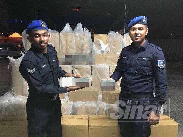 Dua anggota Pasukan Polis Marin Wilayah Tiga bersama sebahagian rokok disyaki rokok seludup yang dirampas.