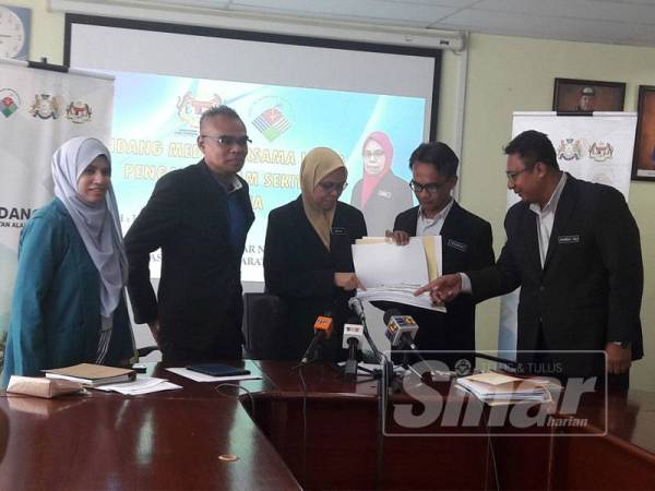 Norlin (tengah)menunjukkan data bacaan kualiti udara kepada Wan Abd Latif (dua dari kiri)