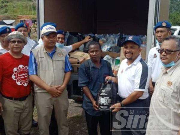 Zakaria (dua dari kanan) menyaksikan penyerahan sumbangan makanan dari Pengarah KPDNHEP Kelantan, Adnan Ab Rahman kepada penghulu, Mohamad Pokok.