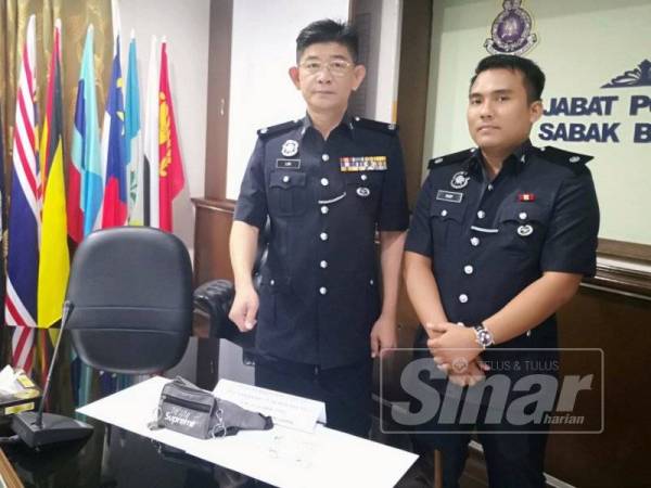 Chee Khoon (kiri) bersama pegawainya menunjukkan barangan dirampas pada sidang media di IPD Sabak Bernam di sini.
