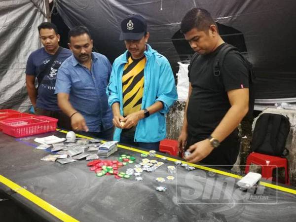 Pegawai Turus D7 IPK Pulau Pinang, Deputi Superintendan Akmal Yahaya (dua dari kanan) membuat pemeriksaan di lokasi serbuan.