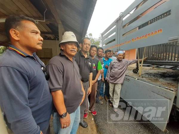 Abdul Malek (tengah) bersama pemimpin penduduk dan anggotanya menunjukkan harimau yang berjaya ditangkap.