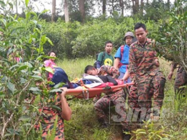 Wanita berusia 48 tahun yang cedera dibantu anggota bomba turun dari Gunung Berembun.