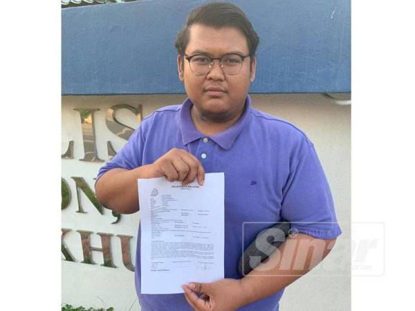 Megat menunjukkan laporan polis yang dibuat di Balai Polis Port Dickson semalam. 