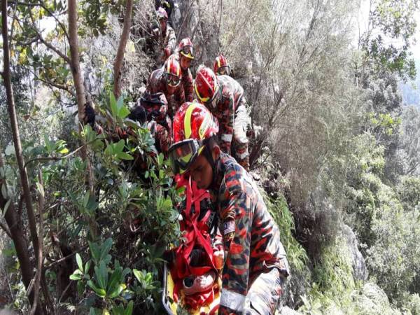 Anggota bomba ketika membawa mangsa turun dari puncak bukit. - FOTO JBPM SELANGOR
