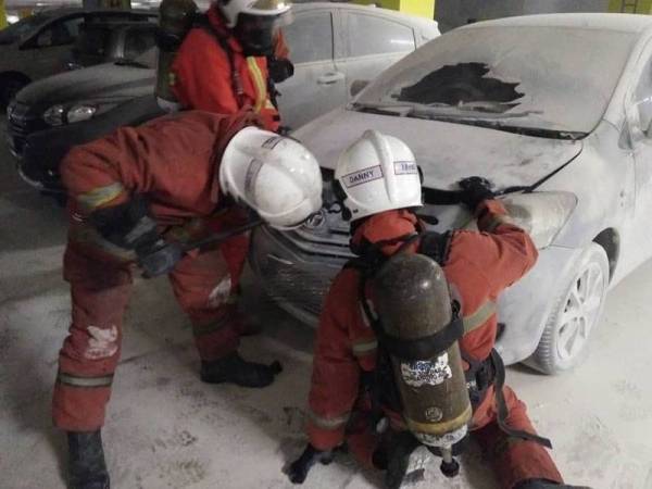 Pasukan bomba memadamkan kebakaran pada sebuah kereta di tempat parkir. - Foto IHSAN BOMBA