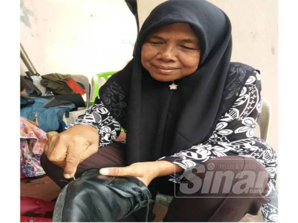 Rasilah tekun menjahit kasut pelanggannya di Jalan selamat di sini sehingga jam 6 petang.