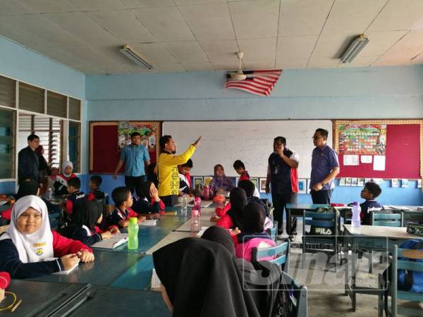 Mohd Khuzzan (kanan) dan Dr Selahudden (dua, kanan) mendengar penjelasan guru berhubung isu pencemaran najis burung di dalam kelas tingkat atas SK Tanjung Puteri Resort.