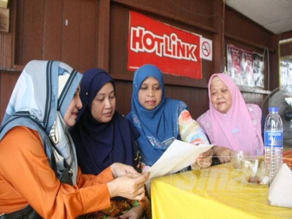 Noraida (dua dari kiri) ditenangkan rakan-rakan sekerja termasuk Rosita (kiri).