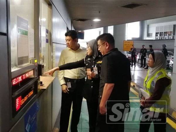 Kah Eng sedang melakukan pemantauan ujian.