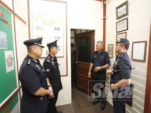 Razarudin (kanan) menemani Tajudin (dua, kanan) melawat Balai Polis Tronoh pada majlis lawatan dan penyerahan perabot.