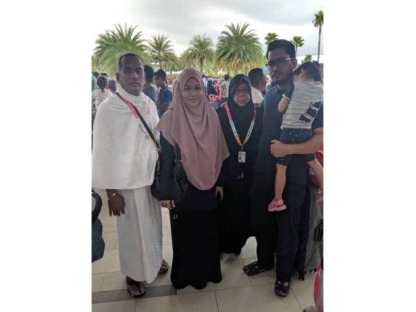 Zakaria (kiri) dan isteri, Halimah (tiga dari kiri) bergambar bersama anak mereka, Nur Liyana (dua dari kiri) dan menantu, Anwar Ahmad, 28, (kanan) sebelum masuk ke balai pelepasan jemaah haji di Masjid KLIA untuk bertolak ke Tanah Suci, sebentar tadi.