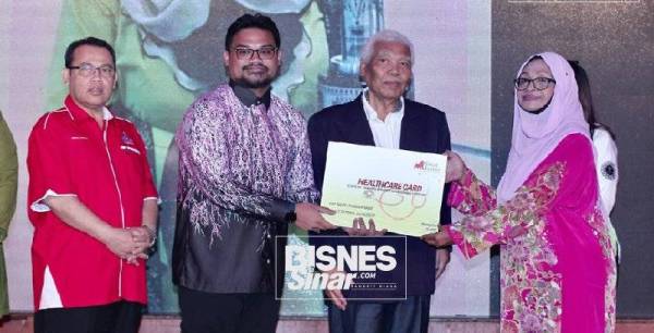 Nordin menyerahkan sumbangan replika kad perlindungan kesihatan kepada kepada Seniwati Negara, Fauziah Nawi pada Pelancaran Program Perlindungan dan Penjagaan Kesihatan Sayangi Hidupku Medicare di Hotel Royale Chulan, Kuala Lumpur semalam.