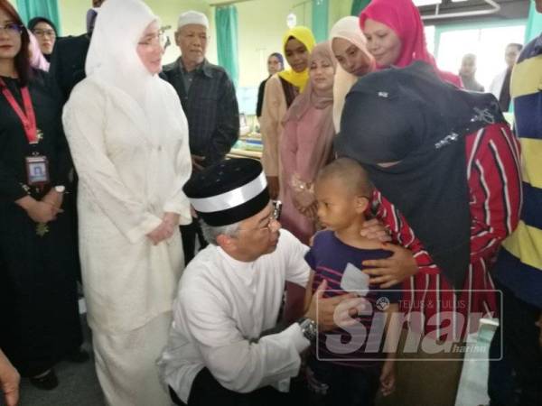 Al Sultan Abdullah beramah mesra Muhammad Alif Asyraf yang hanya mengalami cedera ringan dan terselamat dalam kebakaran tersebut ketika ditemui di HTAA di sini, hari ini.
