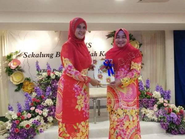 Aishah (kanan) menyerahkan tugas Yang Dipertua Kasih kepada Sohadah pada Majlis Sekalung Budi Seindah Kenangan yang berlangsung di Bangunan UMNO Selangor Shah Alam hari ini.