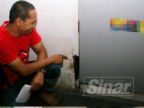 Mohd Harman menunjukkan kesan reput akibat kebocoran di unit didiaminya di Blok AA. 