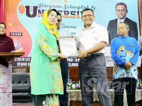 Amirudin menyampaikan cenderhati kepada salah seorang penerima pada Program Selangkah ke Universiti anjuran Yayasan Pelajaran MARA di Dewan Seri Bernam, Sungai Besar hari ini.