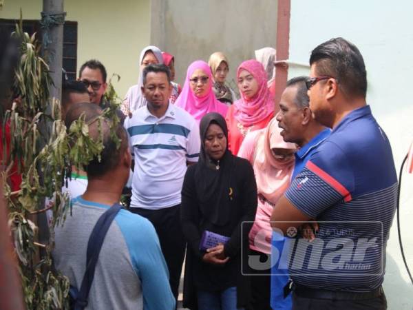 Yusof (dua, kanan) dan Syed Mohd Johan (kanan) berbual dengan mangsa kebakaran di belakang surau Al-Hidayah, Taman Mutiara, di sini hari ini.