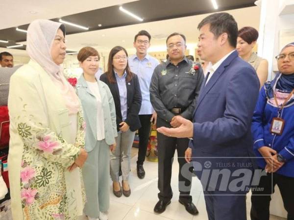 Zuraida (kiri) mendengar penerangan daripada Ketua Pegawai Eksekutif Eastern Decorator Group of Company, Vincent Koay dalam lawatannya ke kilang di Kawasan Perindustrian Khantan, Chemor hari ini.