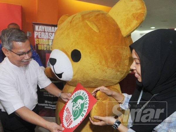 Emran Kadir menerima logo selepas pelancaran logo Surau Hamiddean Bicycle Team 19 sempena Jualan Gudang Pertengahan Tahun Karangkraf di Kompleks Media Karangkraf, Shah Alam. Foto Sinar Harian/Rosli Talib
