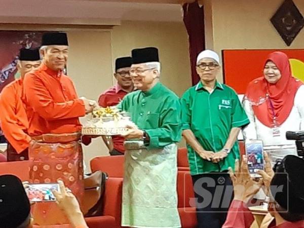 Ahmad Zahid menerima cenderahati daripada Ketua UMNO Bahagian Ipoh Barat, Datuk Shamsuddin Abdul Ghaffar (tiga dari kanan) pada Mesyuarat UMNO bahagian itu hari ini.