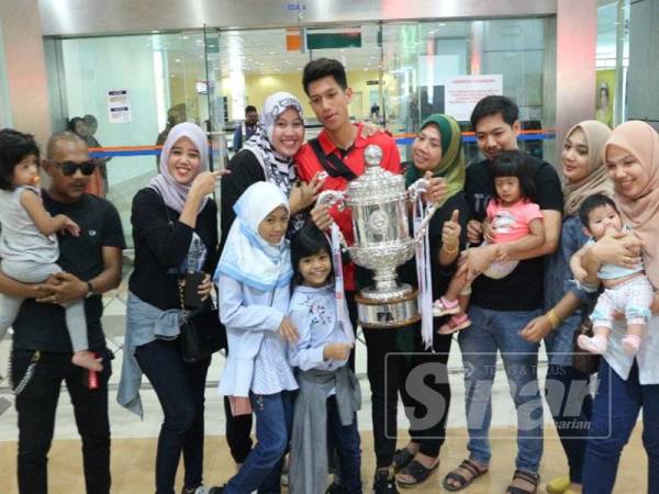 Mohd Fadzrul Danel bergambar bersama ahli keluarganya yang menyambut ketibaan pasukan berkenaan, di sini hari ini.