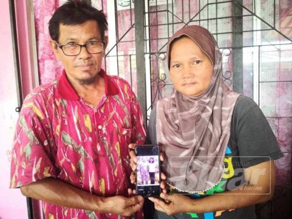 Fadzilah dan suami menunjukkan gambar seorang ahli keluarganya yang pernah menziarahinya sewaktu remaja dahulu.