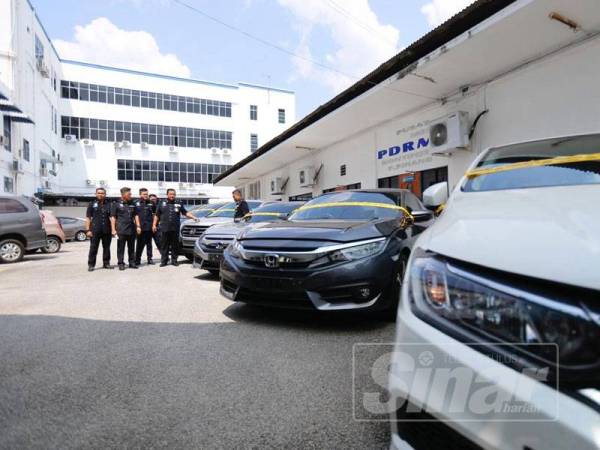 Zainol (empat, kanan) menunjukkan kereta yang dirampas dari sindiket curi kereta.