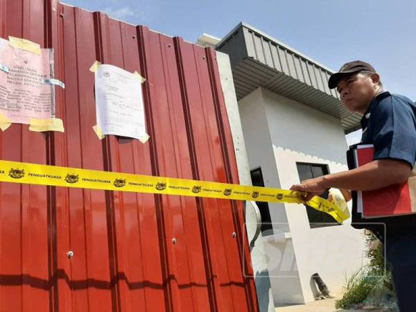 Kakitangan MPPG meletakkan garisan kuning di kilang kitar semula sisa plastik.