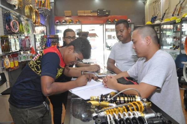 STAF GGR, Muhammad Azri sedang melayan pelanggan melakukan tempahan.