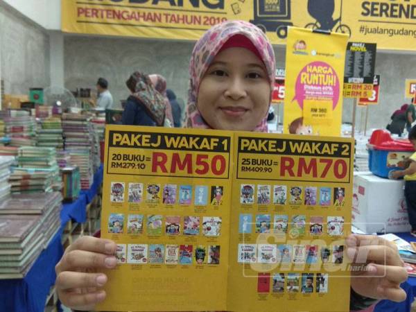 Dahlia menunjukkan antara pakej wakaf buku yang ditawarkan kepada pengunjung sepanjang Jualan Gudang Pertengahan Tahun 2019 berlangsung.