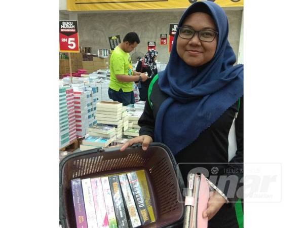 Siti Aishah menunjukkan lapan naskhah novel genre seram dan cinta yang dibelinya.