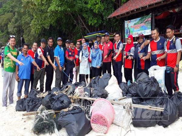Mohd Asmirul (enam dari kanan) dan Zaidi (lima dari kanan) bersama pegawai-pegawai agensi kerajaan menunjukkan sisa-sisa sampah yang berjaya dikutip dalam tempoh beberapa jam.
