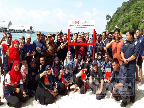 Mohd Asmirul (tengah) bergambar bersama-sama peserta dari pelbagai agensi kerajaan yang menyertai aktiviti gotong-royong di Pulau Payar, Langkawi.