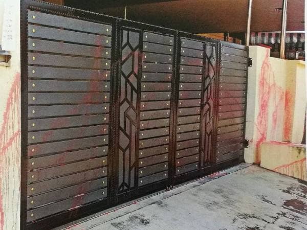 Keadaan pintu pagar rumah Ghee Siew yang disimbah cat merah.