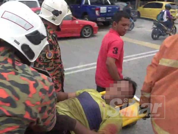 Mangsa yang cedera di kaki dan pinggang diusung ke ambulans sejurus dikeluarkan bagi mendapatkan rawatan.