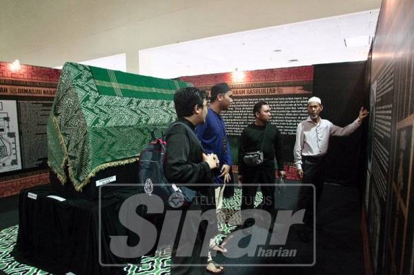 PETUGAS pameran memberi penerangan kepada pengunjung pada Pameran Artifak Rasulullah SAW dan Para Sahabat RA di PWTC, Kuala Lumpur.