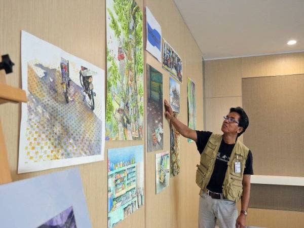 JUHARI Said, peserta dari Pembuat Cetak Malaysia melihat karya seni yang menanginya pada pertandingan tahun lepas.