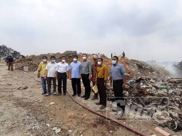 Loy Sian (empat dari kiri) dan Sze Han (empat dari kanan) meninjau lokasi tapak sampah haram yang terbakar sejak Selasa lalu. 