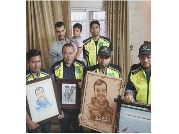 Fitri (kiri) memegang gambar wartawan Yasser Mortaja antara bukti wartawan tidak terlepas dari sasaran kekejaman Israel. Yasser ditembak ketika menjalankan tugas mengambil video dan gambar di perhimpunan Great March of Return pada 6 April 2019, sedangkan dia ketika itu jelas memakai ves kalis peluru yang tertera Press. - Foto Instagram Fitri 