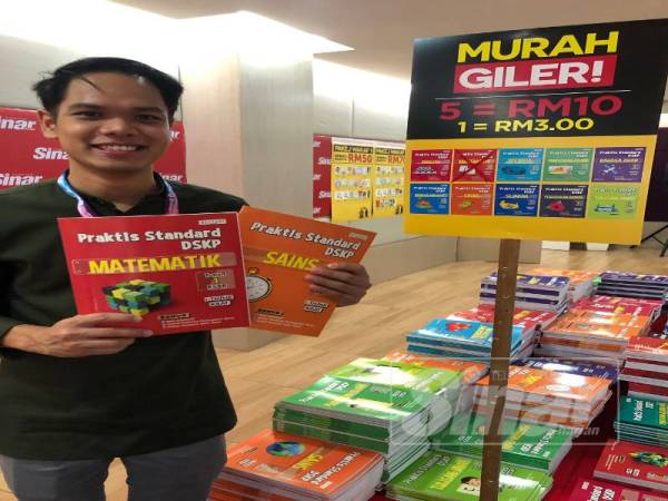 Izzat menunjukkan antara buku latihan yang ditawarkan pada harga sangat berbaloi iaitu lima buku RM10.