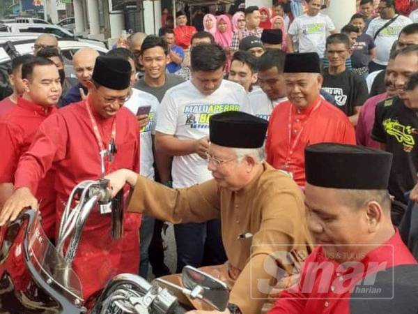 Najib sambil disaksikan Ahmad Shabery dan Ahmad Said menaiki motosikal berkuasa tinggi ketika berarak dengan motosikal dari Pejabat UMNO Bahagian Kemaman ke MPK bagi merasmikan mesyuarat perwakilan bahagian itu hari ini.