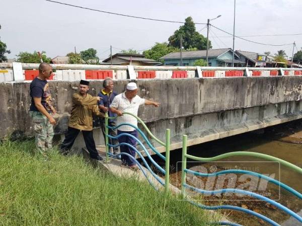 Mohd Zaid (kanan) bersama wakil-wakil masyarakat menunjukkan jambatan sedia ada berdekatan Balai Polis Kuala Besut yang rendah.