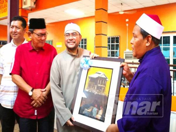 ADUN Sabak, Ahmad Mustain Othman (kanan) menyampaikan cenderhati kepada Mujahid pada Program Dialog Rahmatan Lil Alamin Bersama NGO-NGO Islam dan Komuniti di Pusat Khidmat ADUN Sabak semalam.