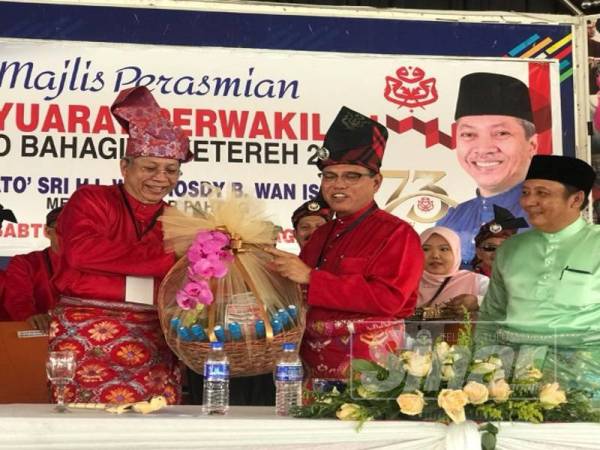 Annuar (kiri) menyampaikan cenderamata kepada Wan Rosdi selepas merasmikan Mesyuarat UMNO Ketereh semalam