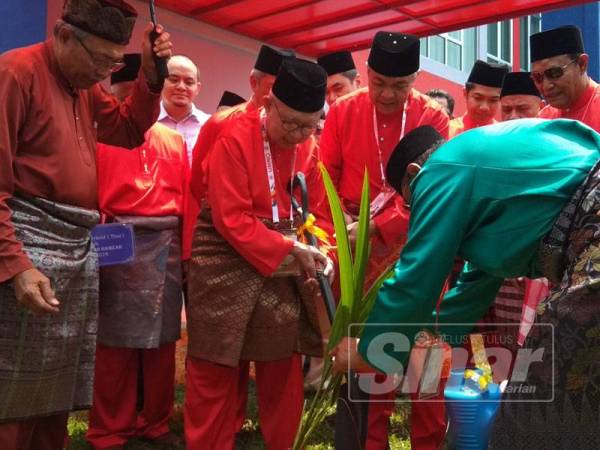 Tengku Razaleigh turut diberikan penghormatan menanam sepokok kelapa jenis matag di perkarangan Kompleks UMNO Bagan Datuk sambil diperhatikan Ahmad Zahid.