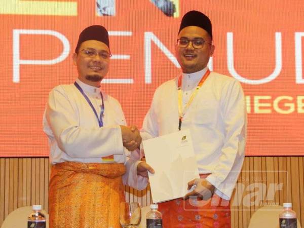 Mohd Zaki menyerahkan tugas Ketua Pemuda Amanah Negeri Sembilan kepada Mohd Hanis (kanan).