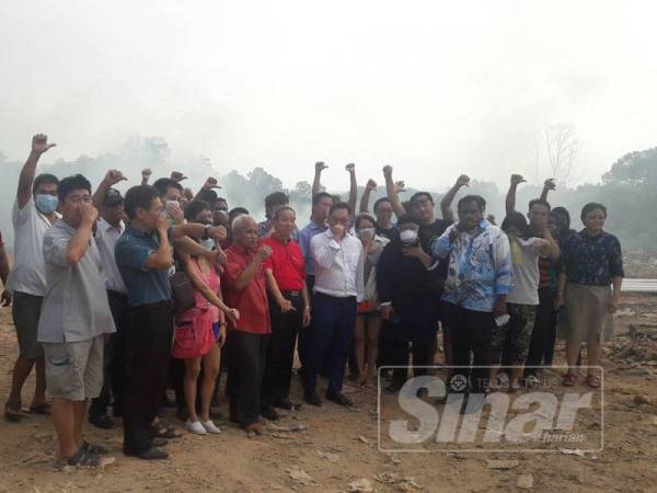 Penduduk bersama Jimmy di tapak pembuangan sampah haram yang terletak di penghujung Jalan Bukit Kempas 4/4, Taman Bukit Kempas.