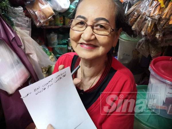 Pok Kiew menunjukkan tulisan jawi yang ditulisnya berbunyi Selamat ulang tahun ke-13 Sinar Harian.